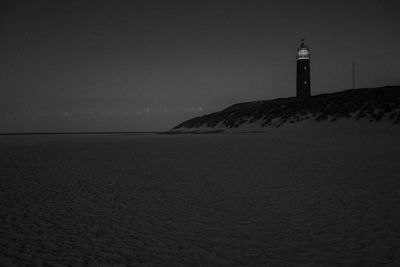 Lighthouse by sea against sky