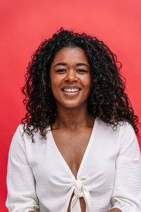 Portrait of young woman against yellow background