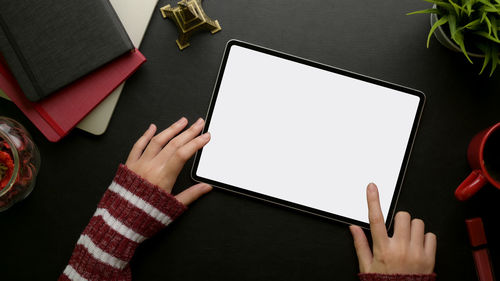 Cropped hands using digital tablet at desk