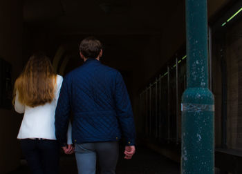 Rear view of couple walking towards tunnel