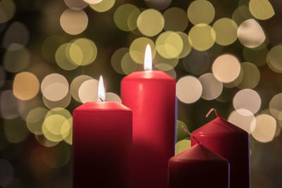 Close-up of illuminated candles against christmas lights