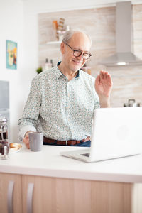 Man using mobile phone while sitting on table