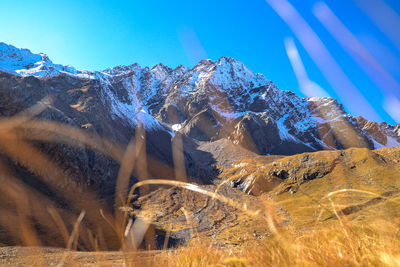 Panoramic view of snowcapped mountains against blue sky