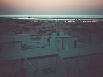 High angle view of buildings by sea against sky