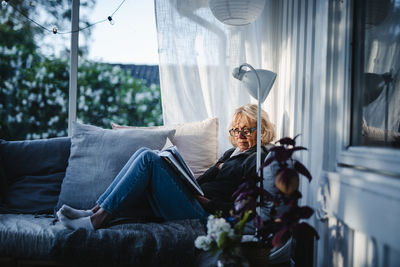 Woman sitting on sofa in conservatory