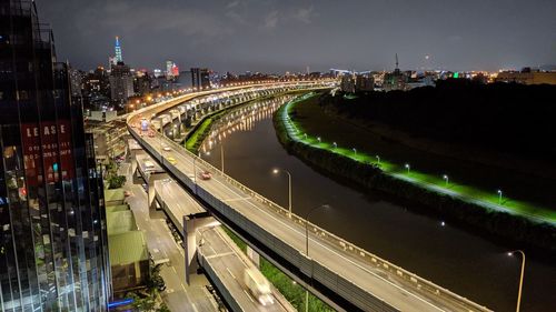 High angle view of illuminated street amidst buildings at night