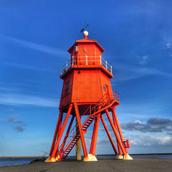 Low angle view of lighthouse by sea against sky