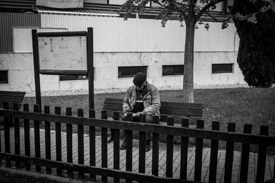 Man standing by railing of building