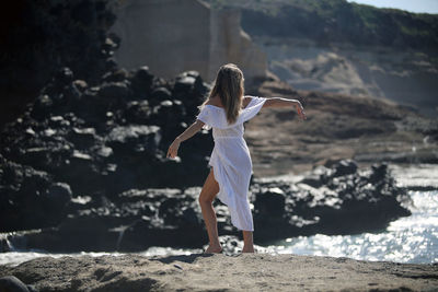 Rear view of woman standing at beach