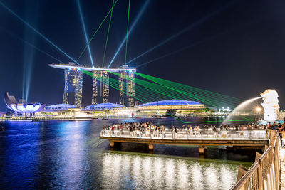 Illuminated bridge over river at night