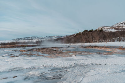 Scenic view of snow covered land against sky