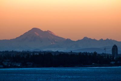 Scenic view of lake and mountains against sky during sunset