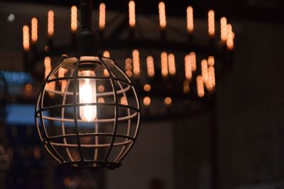 Close-up of illuminated lighting equipment hanging