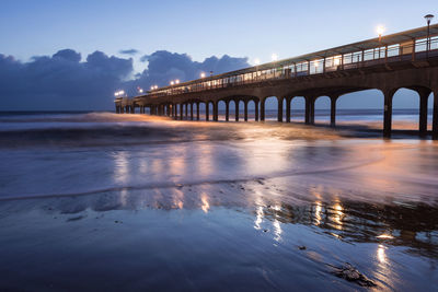 Bridge over sea against sky during sunset