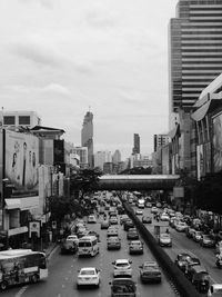 Cars on city street against sky