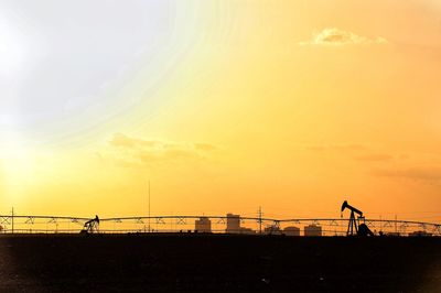 Summer heat with silhouette of pump jacks and city