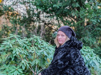 Portrait of mature woman in warm clothes standing outdoors