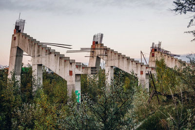 Low angle view of bridge in city against sky