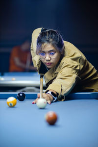 Portrait of woman playing pool