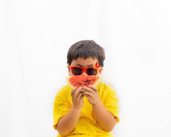 Portrait of boy wearing sunglasses against white background