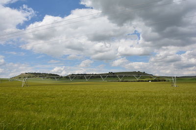 Scenic view of field against cloudy sky