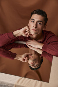 Portrait of young man reflecting in mirror