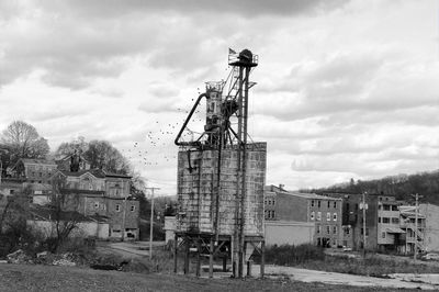 Old abandoned building on field against sky