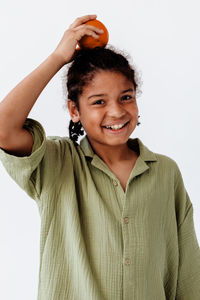 Portrait of young woman standing against white background