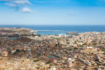 High angle view of townscape by sea against sky