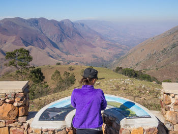 Rear view of woman standing at viewpoint in mountains, south africa