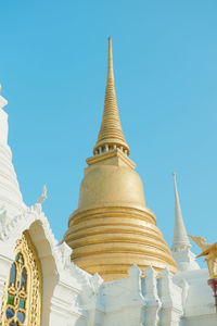 Low angle view of golden pagoda against clear sky