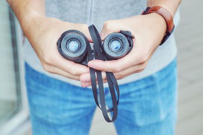 Close-up midsection of man holding binoculars