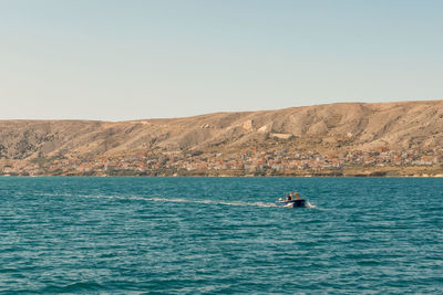 Man surfing in sea against clear sky