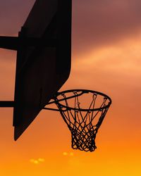 Low angle view of basketball hoop against sky during sunset