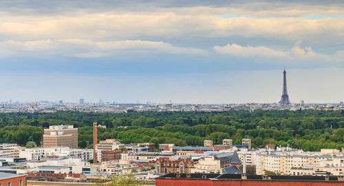 Buildings in city against cloudy sky