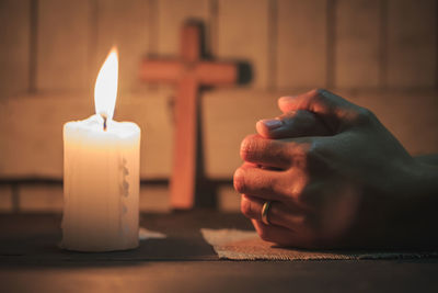 Close-up of hand holding burning candle