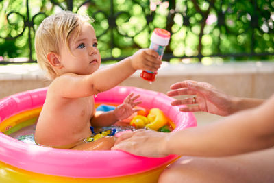 Midsection of woman holding baby in water