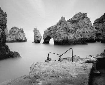 Rocks by sea against sky