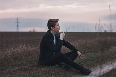 Young man sitting on field