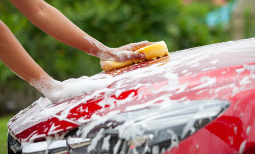 Cropped image of hand washing car