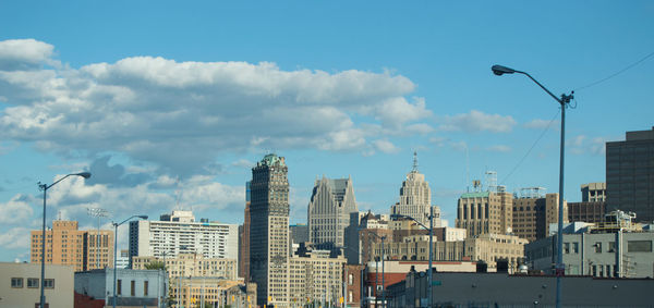 Buildings in city against cloudy sky