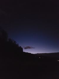 Silhouette landscape against sky at night