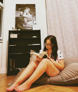 Young woman sitting on sofa at home