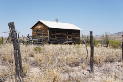 Abandoned house on field against clear sky