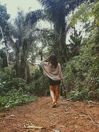 Rear view of woman walking in forest