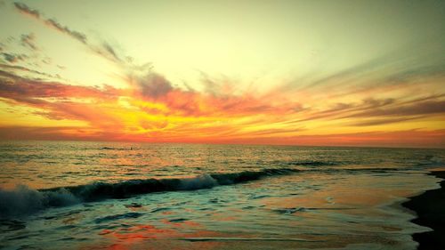 Scenic view of sea against dramatic sky during sunset