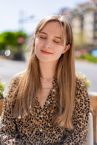 Portrait of young woman standing against trees