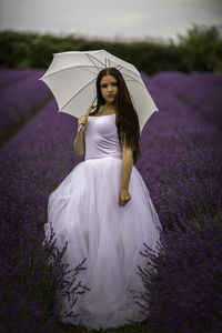 Woman standing on purple flower on field