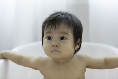 Close-up of cute baby girl sitting in bathtub
