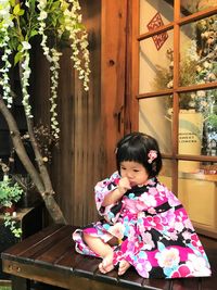 Portrait of cute girl sitting outdoors